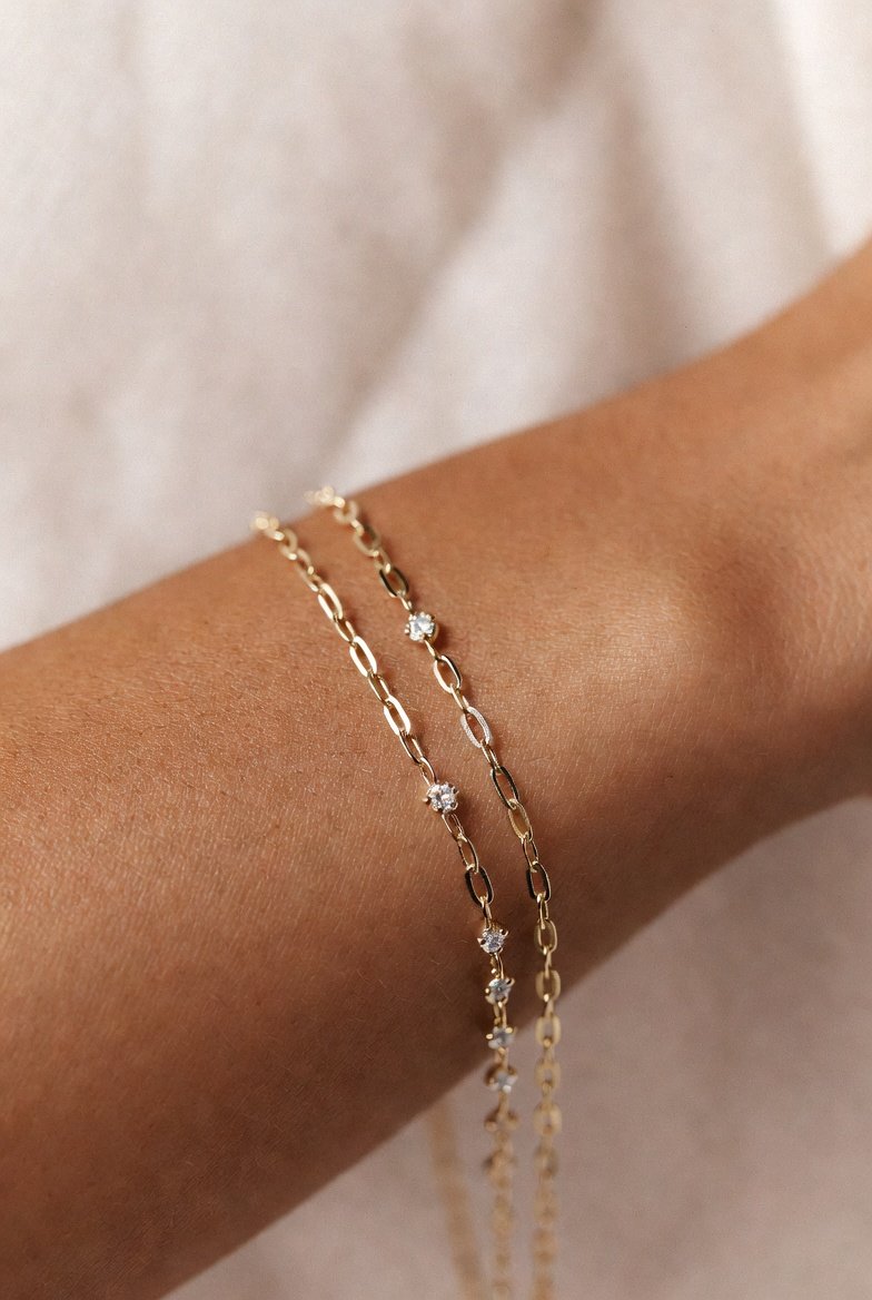 Delicate bracelet detail on warm bronzed skin